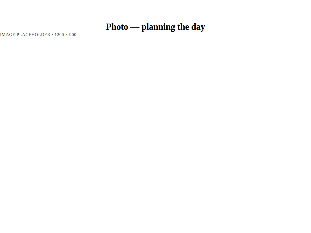 A person planning their day at a desk, notebook and laptop in morning light